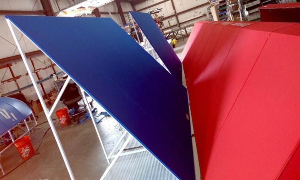 Blue and red metal panels displayed in an industrial warehouse setting.