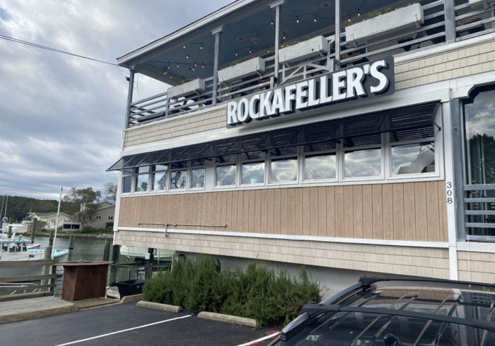 Exterior view of Rockafeller's restaurant by the waterfront, featuring a two-story deck.