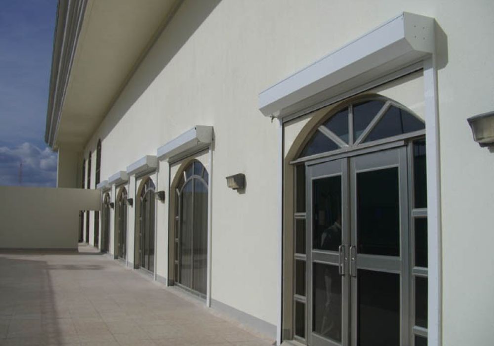 Arched glass doors on an exterior wall under the sunny sky, creating a modern architectural facade.