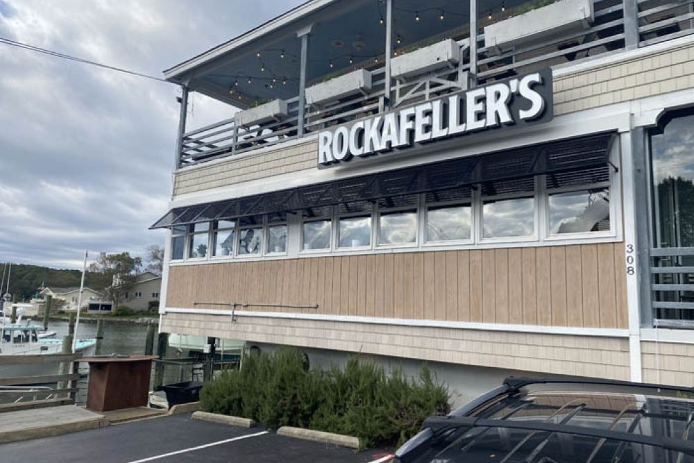 Exterior view of Rockafeller's restaurant by the waterfront, featuring a two-story deck.