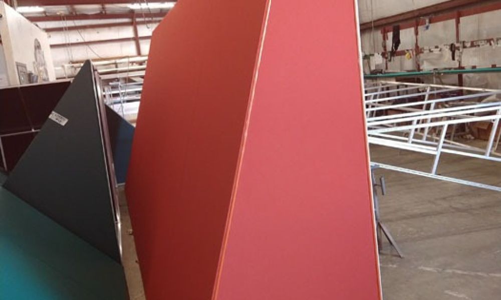 Large red and blue geometric structures in a warehouse, showcasing modern architectural design elements.