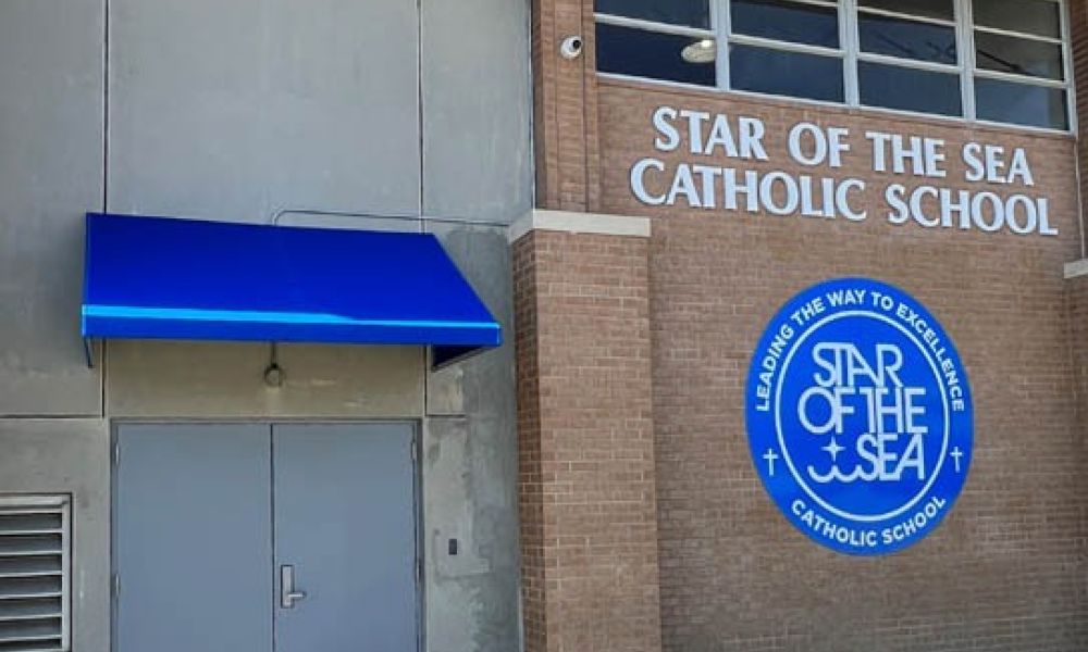 Exterior view of Star of the Sea Catholic School with logo and blue awning.